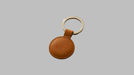 Brown leather keychain with a white ring on a white background
