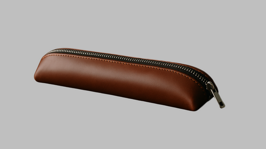 Brown leather pencil case with a zipper on a white background